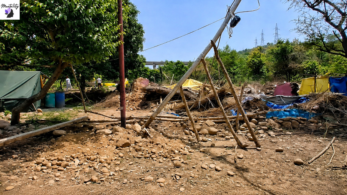 Makeshift shelters, damaged structures, and debris remain at the site